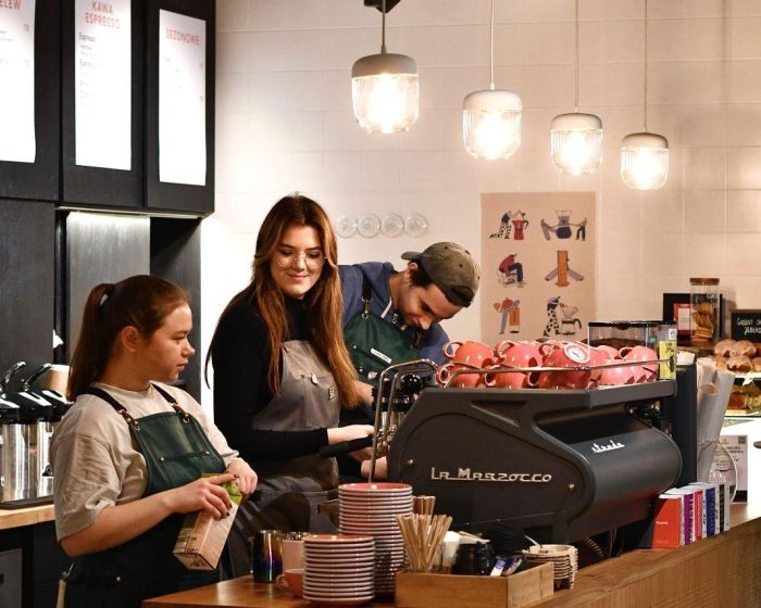 Head barista i zespół baristów podczas przygotowywania kawy za barem w Coffeedesk Próżna 7.